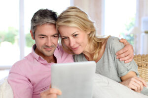 Couple at home using electronic tablet